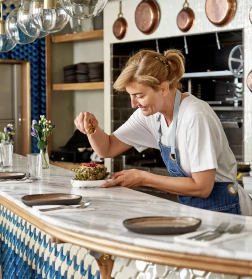 Esra Muslu finishing a dish at the counter